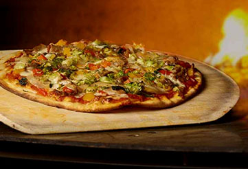 Pizza by a brick pizza oven